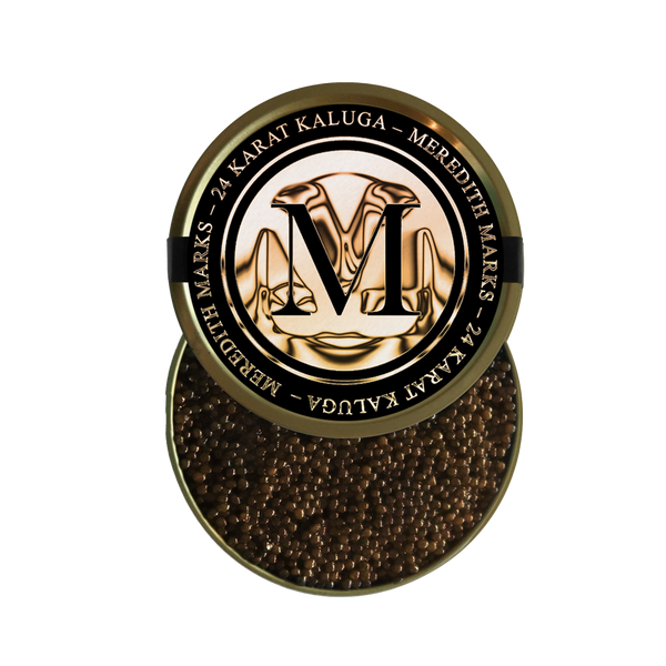 A luxurious open tin of Meredith Marks “24 Karat Kaluga” caviar-the gleaming gold lid embossed with an ornate ‘M’ and branding rests beside glossy, uniformly rich brown pearls packed inside.